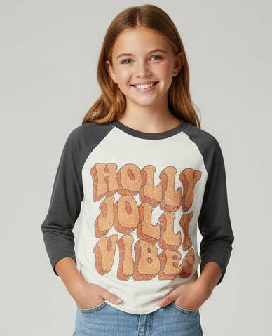 Child wearing a gray and white baseball shirt with text and blue jeans on a plain background