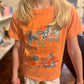 Child wearing an orange t-shirt with taylor swift life of a showgirl graphic design and text
